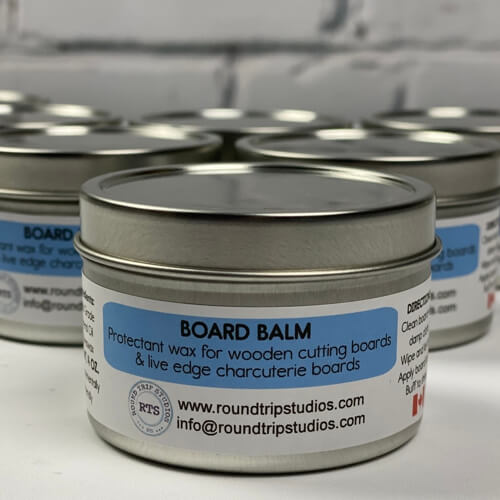 Containers of board balm wood conditioner on the kitchen counter.