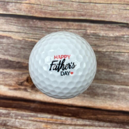 Golf ball printed with happy Father's day.