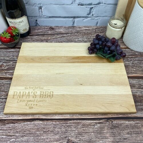 Custom cutting board with BBQ design engraved in the corner.