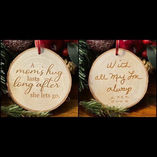 Rustic birch ornament with handwriting on one side and the saying "A Mom's hug lasts long after she lets go" on the other.