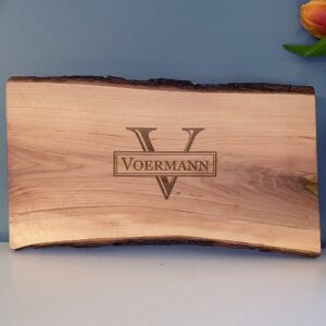 Live edge wood serving board with initial and name engraved.