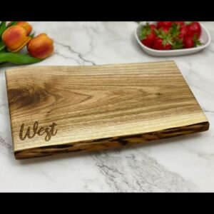 Live edge charcuterie board with a family name engraved in the corner.