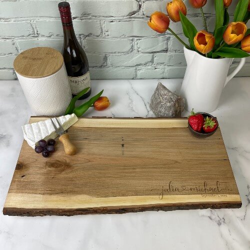 Engraved cheese board with first names connected with a heart.