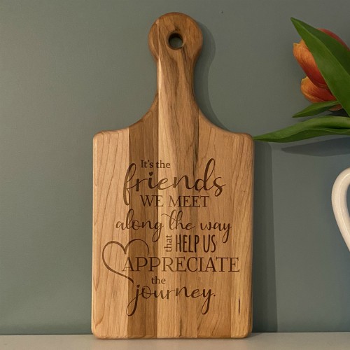 Engraved cutting board with a saying about friendship.