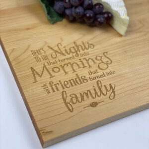 Custom wood cutting boards with a saying about friendship engraved in the corner.
