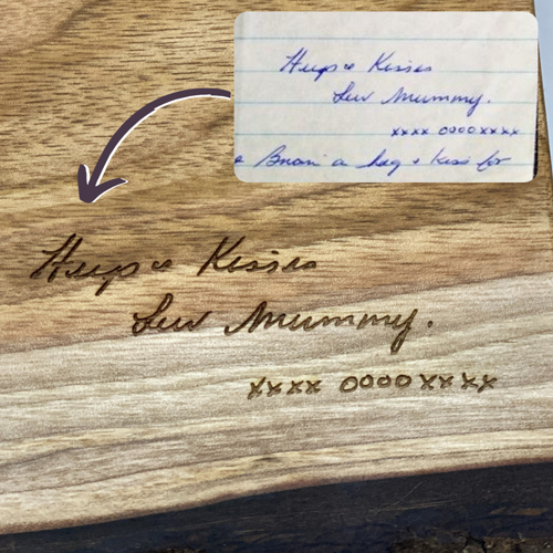 Handwriting from a card or letter engraved on a wood serving board.