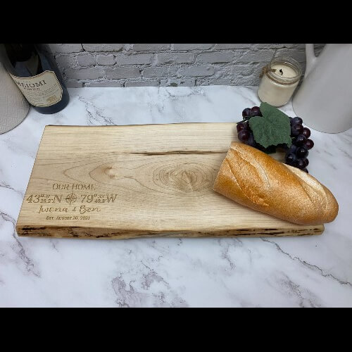 A charcuterie board designed with the GPS coordinates and the couples name and date. Makes a thoughtful housewarming gift.