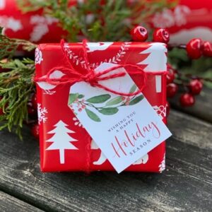 Gift box wrapped in holiday gift wrap with gift tag attached.