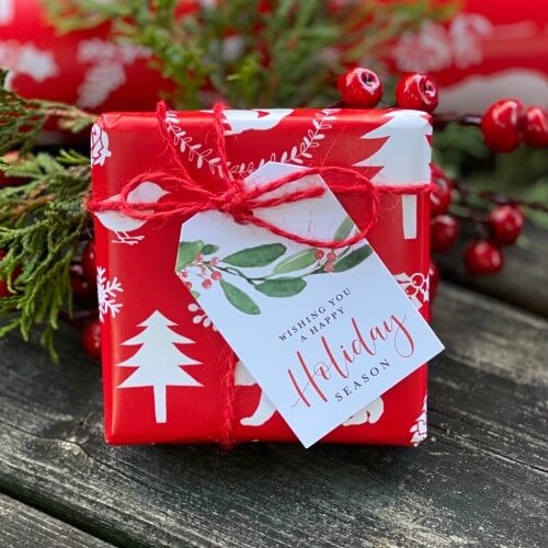 Gift box wrapped in holiday gift wrap with gift tag attached.